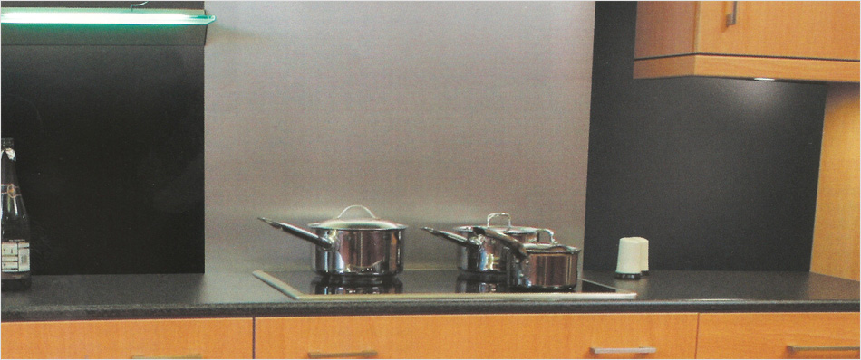 Black granite worksurface with brushed aluminium splashback